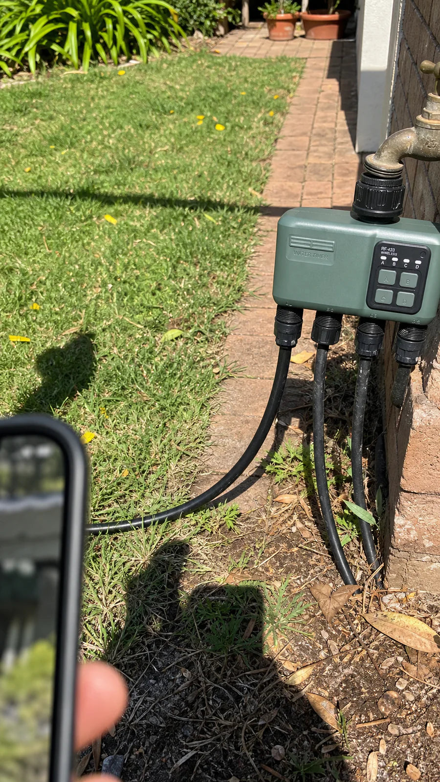 Johgee water timer in a sunny villa lawn garden scene
