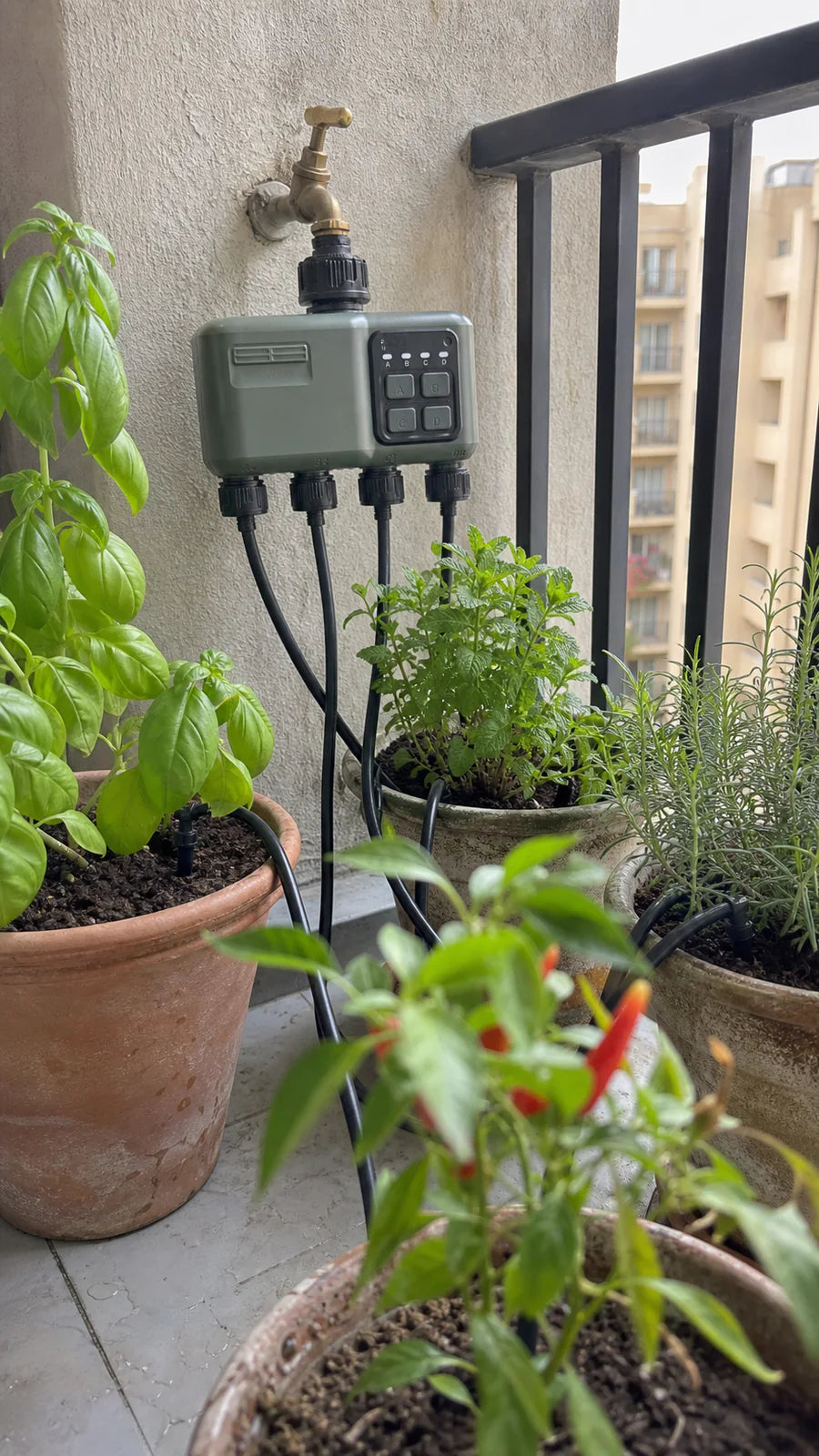 Smart water timer in a balcony herbs garden scene